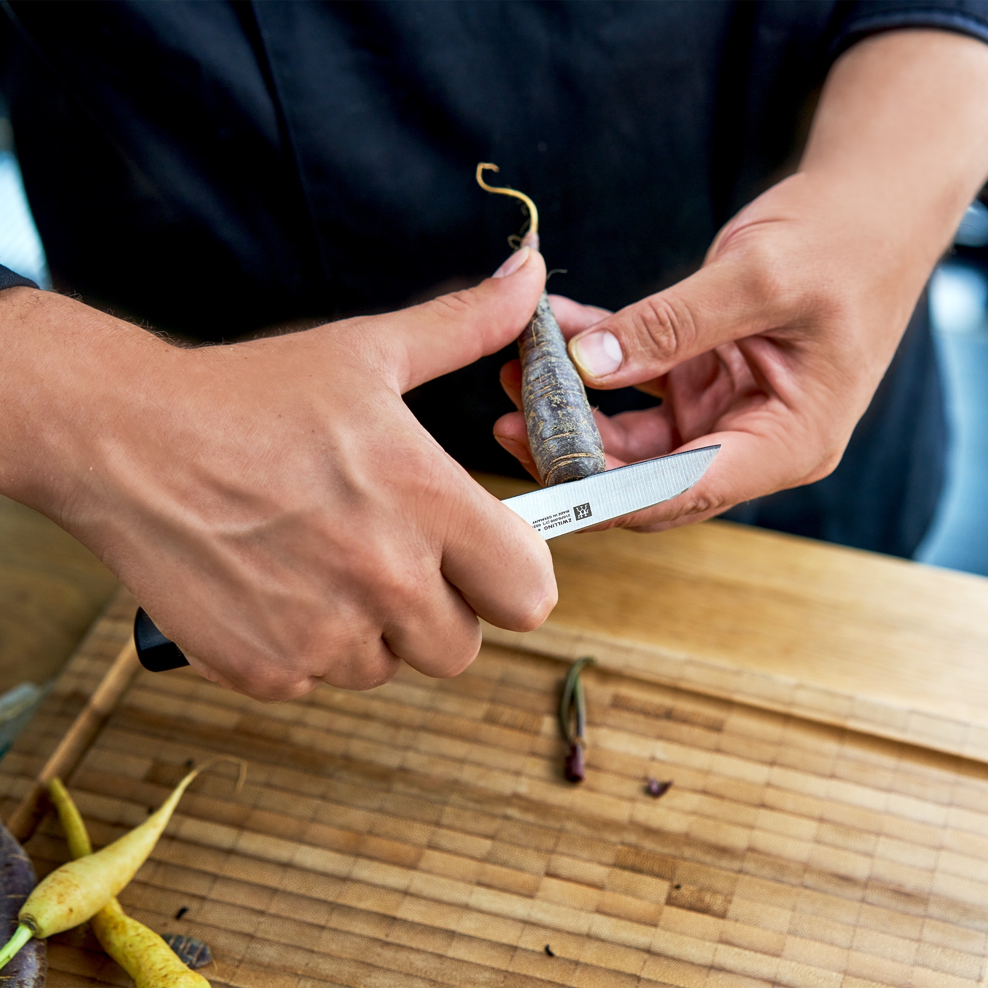 Hand schält Karotte mit kleinem Gemüsemesser